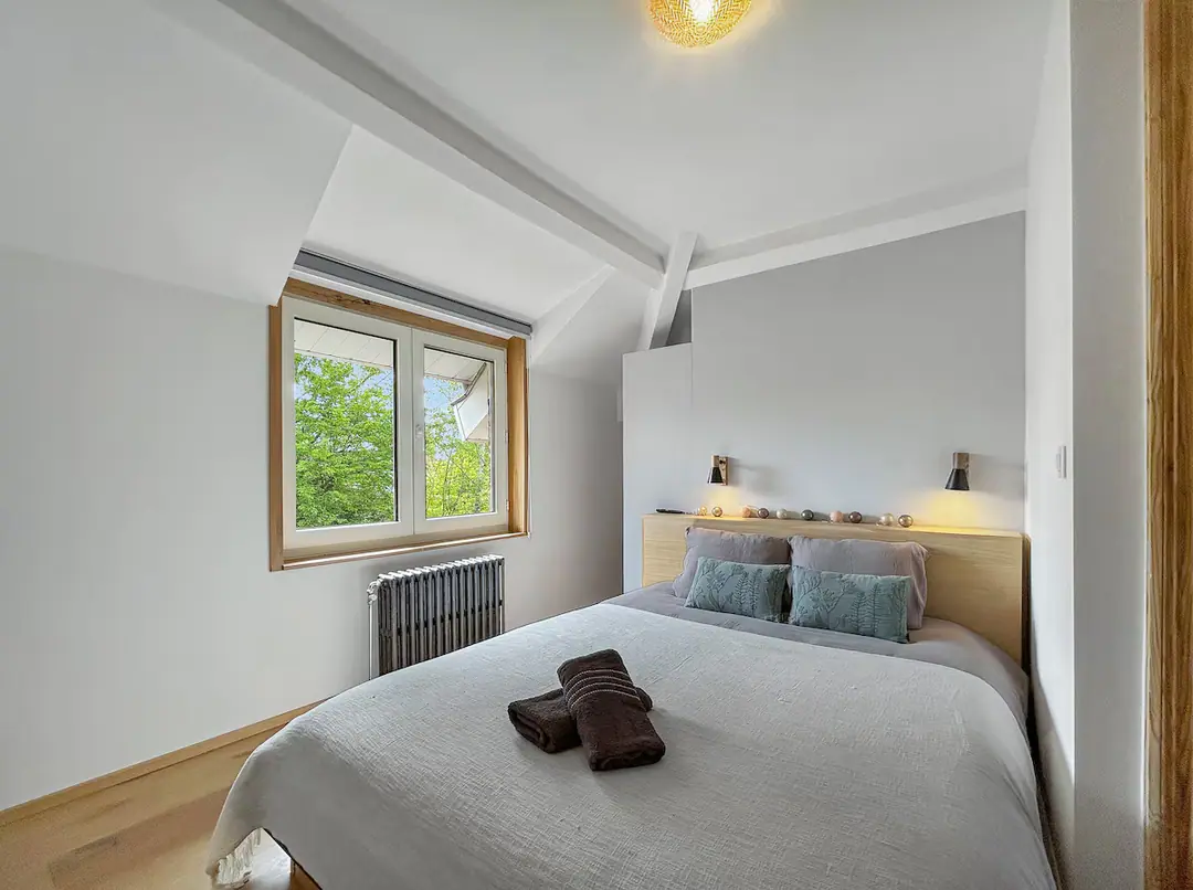 Chambre lumineuse, lin lavé et tête de lit en chêne.