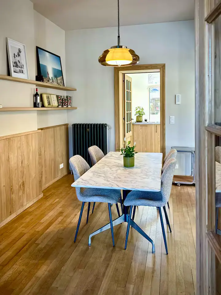 La grande table à manger sous les suspensions en laiton.