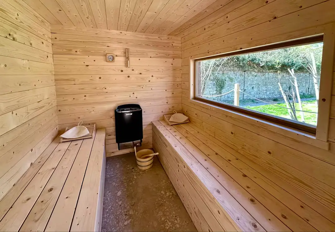 Le sauna privé en bois clair, face au jardin.